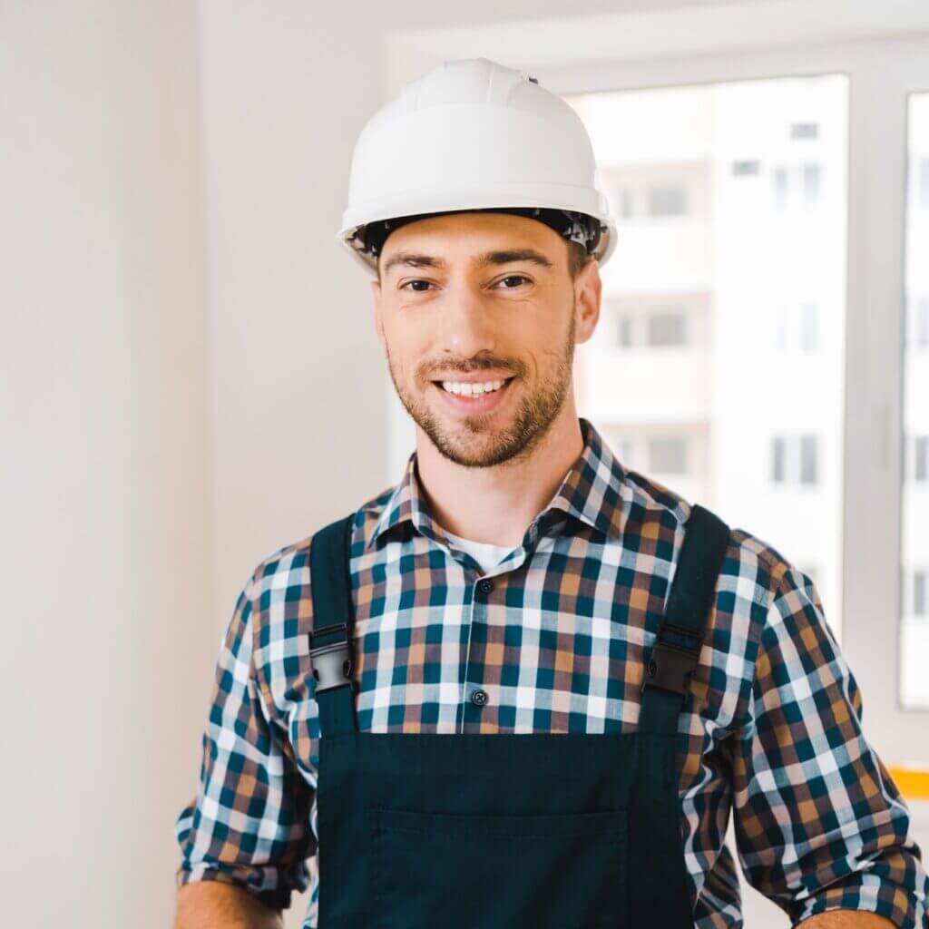 cheerful handyman holding wrench and showing thumb up